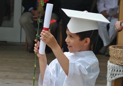 Clad in caps and “gowns,” prekindergartners graduating from the Eleanor Whitmore Early Childhood Center on Friday morning got a diploma and a red carnation.