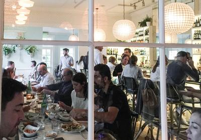 A window view of the dining room and bar at Wolffer Kitchen’s latest venue, in Amagansett