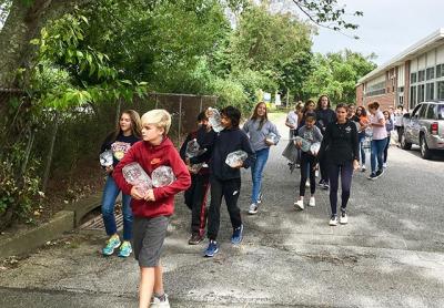 Learning by doing, East Hampton’s seventh graders experienced the arduous task of carrying water from the middle school to the high school and back, which tied in to the subject of a book they are reading in class as well as a film project they are working on in conjunction with the Hamptons International Film Festival.