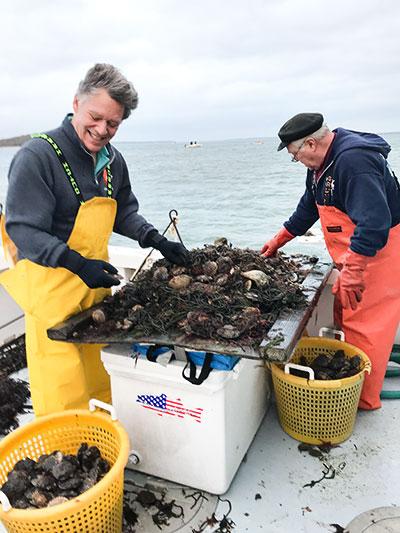 Robert Cugini of Seattle and Ray Sperling of Sag Harbor helped sort through scallops on Monday morning.