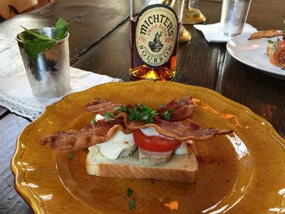 A Kentucky “hot brown” sandwich, above, often follows a day or night of drinking the bourbon-heavy mint juleps seen in the background.