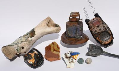 The pieces of history that turned up on Havens Beach included a musket ball, an oil lamp, and a coin minted in 1875.