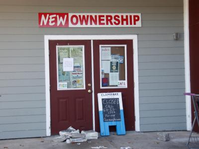 “Due to owner disagreements Hampton Beverage East was forced to close on July 31,” reads a sign on the door of the Pantigo Place, East Hampton, business. The building, which is shared by Goldberg’s Bagels, is for sale.