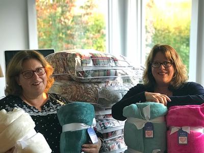 Nina Landi, left, and Daisy Dohanos with some of the blankets they are collecting for hospice patients