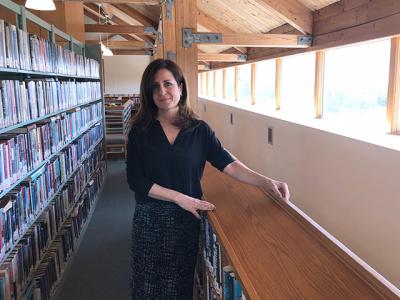 Denise DiPaolo, director of the Montauk Library, in the mezzanine area, which is now open to the main floor of the building. Under a proposed renovation and expansion plan, most of the open areas would be filled in, creating more space on that level and improving acoustics throughout.