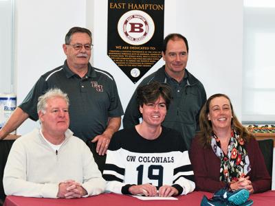 Ryan Fowkes, center, signed Monday a letter of intent to attend George Washington University in Washington, D.C. He was flanked by his father, Bill, and his mother, Jennifer, with Bill Herzog, his middle school coach, and Kevin Barry, his varsity cross-country coach, behind him.