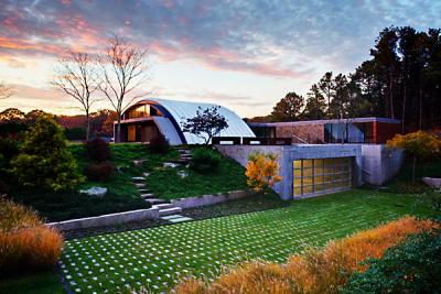 A view of the Arc House from the driveway shows the original design with the flat-roofed sleeping quarters behind it.