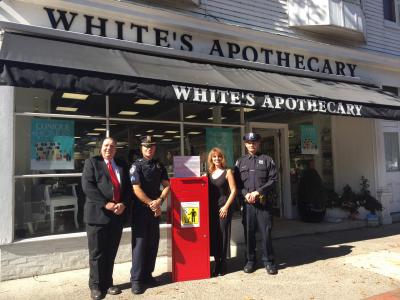 White's Apothecary is sponsoring another "Big Red Med" drug disposal box, to be used by town and village police at community events. From left are Tom McAbee, creator of the Big Red Med disposal box, Sgt. Daniel Roman, Diana Dolling-Ross, owner of White's Apothecary, and Police Officer Kenneth Alversa.