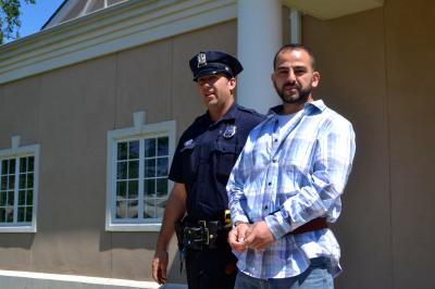 An East Hampton Village Police Officer led Valon Shoshi out of East Hampton Town Justice Court on Thursday after he was arraigned on two felony charges.