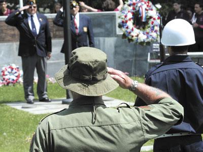 Fred Overton, rear left, commander of East Hampton American Legion Post 419, saluted fellow veterans at the Hook Mill green on Monday.