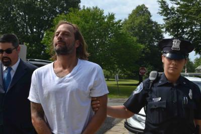 An East Hampton Town police officer led Dylan Eckardt led into East Hampton Town Justice Court Tuesday morning, with his attorney, Trevor Darrell by his side.