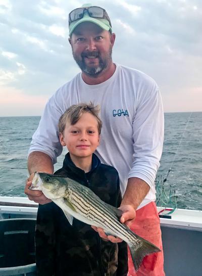 Rudy Bonicelli, first mate on the Montauk charter boat Oh Brother!, helped Timmy McKenna release a striped bass they had just caught.