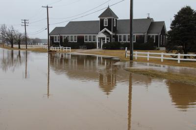 The writer's car got stuck in the mud because of the flooding in front of the Wainscott School on Sunday. Elisha Osborn happened to pass by, came back to get the car out of the mud, and then invited her to a party.