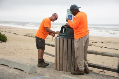 Tony Medeiros and Ray Gilliam of the East Hampton Village Department of Public Works secured garbage can lids in anticipation of high winds associated with Jose.