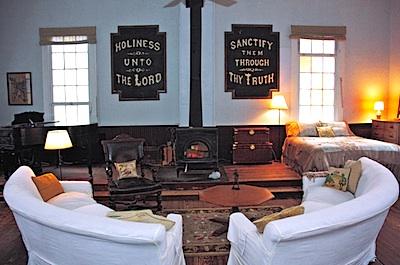 The sitting area faces what had been the front of the church, and a wood-burning stove has taken the place of the lectern.