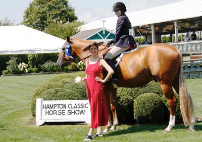 Iris Smyles awarded The East Hampton Star-sponsored Local Hunter Pro Hampton Classic championship prize to Holly Orlando on O.