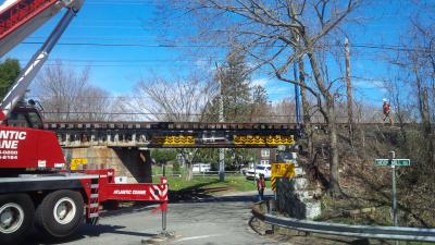 A crane with a boom approximately 80 feet long was brought in to make repairs to the train trestle after it was struck on Monday morning.