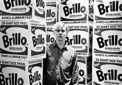 Fred W. McDarrah captured Andy Warhol at a Stable Gallery opening on April 21, 1964. Below: This 1965 image of Bob Dylan sitting on a bench outside The Village Voice’s offices was used on his “Complete Album Collection Vol. One” in 2013.