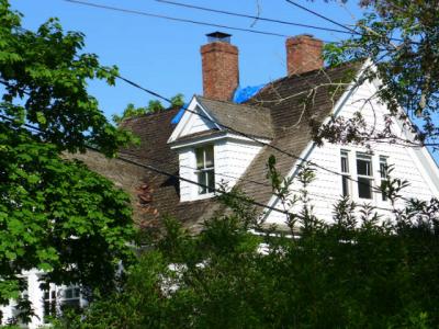 A blue plastic tarp covered a portion of the roof of an Amagansett house that was damaged in a fire on Saturday night.