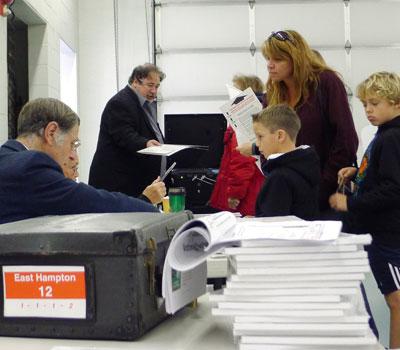 A voter, accompanied by two boys, checked in with Board of Elections poll-watchers at the Amagansett Fire House early Tuesday.