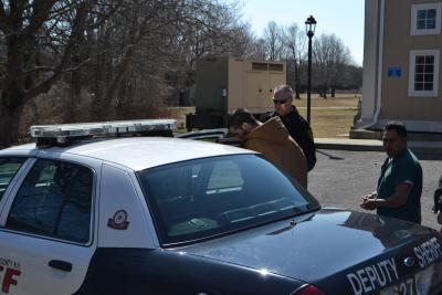 Joseph R. Spezzano ducks his head as he gets into a Suffolk County Deputy Sheriff's vehicle for the county jail, where he will spend the next six months.