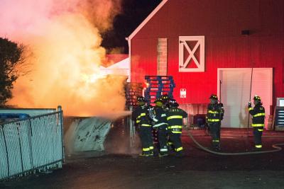 Firefighters doused flames after a fire started in a Dumpster and spread to wooden pallets in the Hampton Beverage and Goldberg's Bagels complex Friday night.