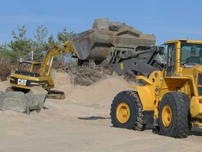 Workers placed boulders in front of a Georgica Beach property Wednesday while a lawyer for the East Hampton Town Trustees sought a court injunction to stop them.