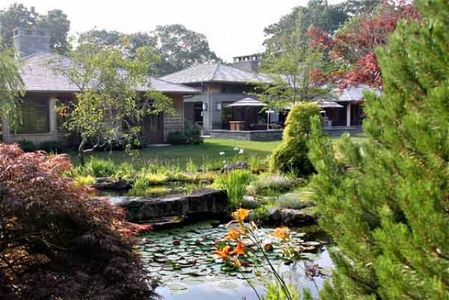 The main house, with cues from Japanese architecture and Frank Lloyd Wright, is large but nestled into the landscape. It faces part of the water garden.