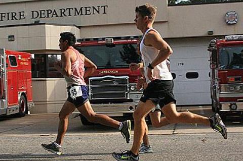 Angel Rojas and Jason Hancock, passing in front of the Springs firehouse above, were to finish second and third in Labor Day’s 10K.