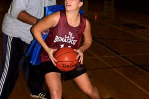 Nicole Miksinski, going to the hoop after having maneuvered around her coach, Howard Wood, during Saturday’s practice session, is expected to be one of the starters.