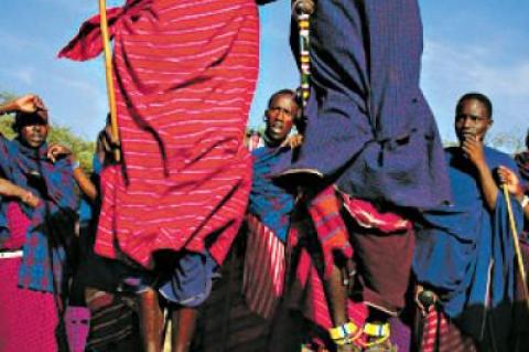 Young Masai men perform a traditional warrior dance. Kenny Mann’s earliest years were spent on her father’s cattle ranch on Masai land at the Athi River in Kenya.