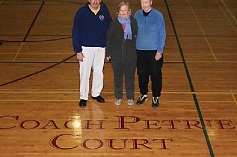 Coach Ed Petrie, the state’s winningest public high school boys basketball coach, his wife, Nancy, and Joe Vas, left, the East Hampton School District’s athletic director, admired the new “Coach Petrie Court” logo at the high school.