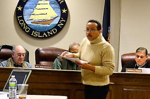 Michael Butler distributed photos to the village board, describing how the proposed Harbor Heights application would affect his neighboring property.