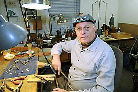 John Iversen sat at his worktable in East Hampton on a recent afternoon.