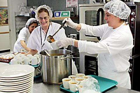 Debra Kulp, center, and Dee Hallock ladled out cups of soup in the kitchen at the East Hampton Town Senior Citizens Center last month. Behind them was Paula Bahmondes.