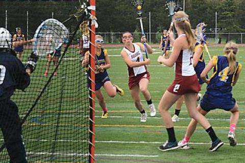 Maggie Pizzo, driving in on the North Fork team’s cage, led East Hampton’s scoring with three goals.