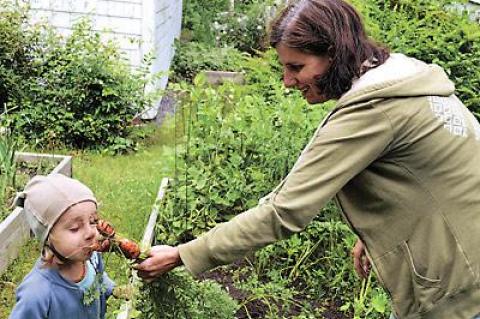 Mare Dionara’s son, Finny, enjoyed the smell of carrots pulled from their backyard garden, where they hope to have chickens.