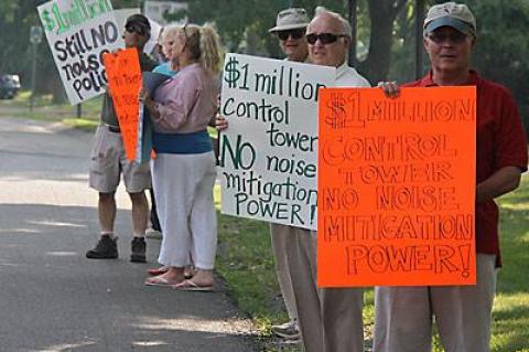 Before last Thursday’s East Hampton Town Board meeting, members of the Quiet Skies Coalition, angry about a new control tower at East Hampton Airport, stood outside Town Hall with signs decrying the tower and Councilman Dominick Stanzione, who oversees airport matters for the town board.