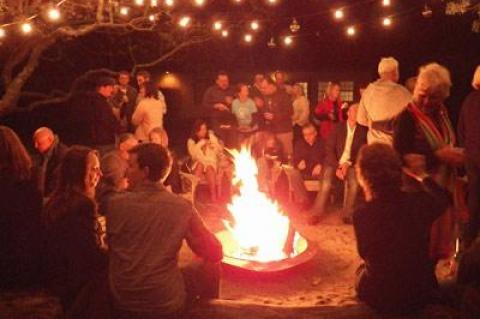 People gathered around a fire in the courtyard at Solé East during a fund-raiser there in June. The resort has announced plans for a three-day music, yoga, and fashion festival next month.