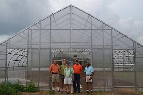 Fine produce — and flowers, too. Ira Bezoza, Darcy Hutzenlaub, John Malafronte, Bruce Warr, and Peter Garnham stood in the doorway to the East Hampton Food Pantry Farm’s recently added greenhouse. Left, young participants worked recently with Eliza Kellman, a summer intern at the farm’s herb garden.