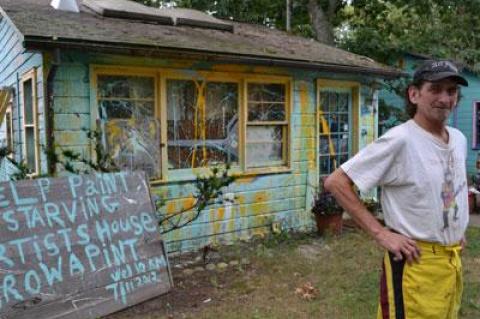 Rian White responded to an East Hampton Town citation about peeling paint on his house by inviting passers-by to help decorate it in whatever fashion moves them. He provided the supplies.