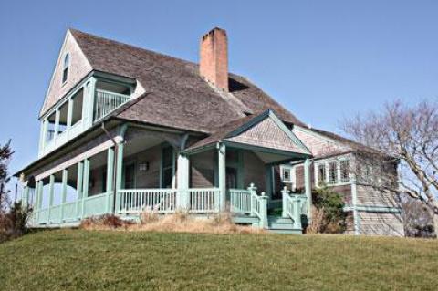 The Andrews House, one of seven late 19th-century Shingle Style cottages in the Montauk Association, enjoys views of the ocean from its first and second-story verandas. A small kitchen addition at right was designed by Francis Fleetwood.