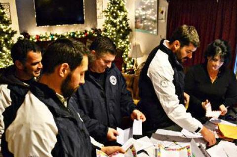 Coach Rich Brierley, far left, and players Nicholas Lawler, Ryan Borowsky, and Nick Finazzo stopped by the home of Melissa Ann Mitchell, at right, to pick up letters of support for residents of the Rockaways.