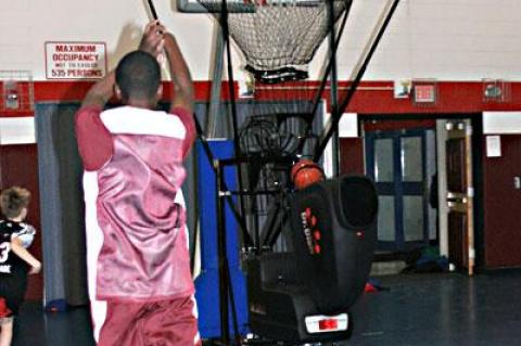 The conical mesh net around the hoop not only funnels balls into the dispatching machine, but also is set at a height that only accepts soft arc shots, not line drives.