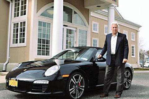 Michael J. Griffith, international lawyer and inspiration for a new television series, stood by his Porsche Carrera S, “which never leaves the Hamptons,” outside East Hampton Town Justice Court on Saturday.