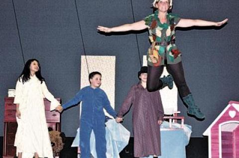 The Darling children, from left, Paula Guerra, Colin Freedman, and Dillon Andrada, watched Peter Pan, played by Jayne Freedman, take flight.