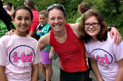 The women’s winner, Ali Crum, posed after crossing the line with two  I-Tri volunteers, Maliaq Guebli and Sarah Havens.