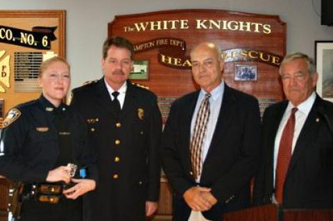 Jennifer Dunn, left, has joined the East Hampton Village Police Department as an officer after eight years as a dispatcher. She attended Friday’s village board meeting with, left to right, Chief Gerard Larsen Jr., Richard Lawler, a village board member, and Mayor Paul F. Rickenbach Jr.