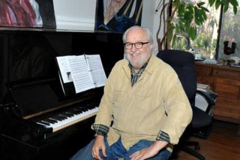 Roger Ames makes music at a piano, electronic keyboard, and laptop at his house in Springs.