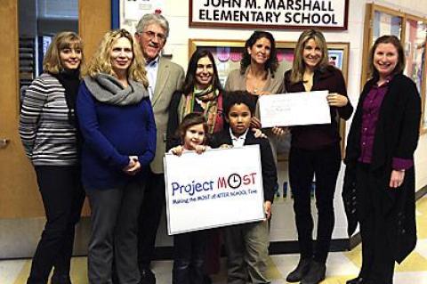 The founders of the Hamptons Marathon, Amanda Moszkowski and Diane Weinberger, holding the check in back, got a big thank-you for their donation to Project Most at the John M. Marshall Elementary School Friday from Christina DeSanti, Beth Doyle, the school principal, East Hampton Town Supervisor Larry Cantwell, Anita Wright, a parent, Rebecca Morgan Taylor of Project Most, and two kids who take part in the program.